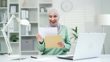 Heyecanlı genç Müslüman kadın, proje çalışmalarında veya maaş artışında büyük bir başarı gösteren bir mektup aldı. Mutlu girişimci içeride iyi sonuç aldı.