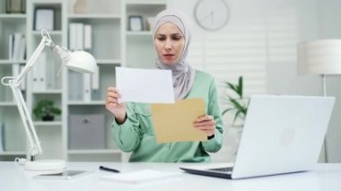Kadın açık mektup zarfı, kötü haberlerle dolu. Ofis işyerinde oturan olumsuz sonuçlu bir tebligat. Ödeme vergisi faturası ya da iflas ihtarı için banka borcu faturası.