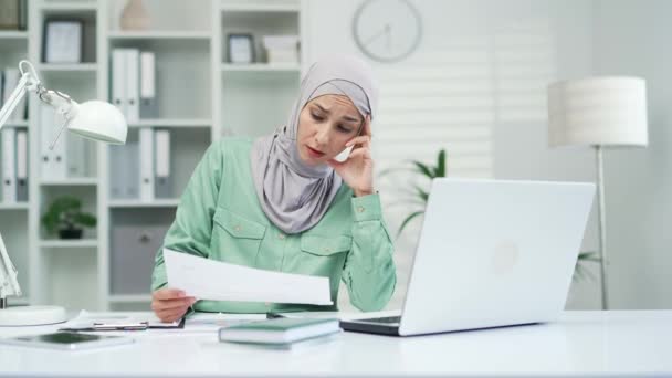 書類仕事の疲れイスラム教徒のアラブ女性の金融会計士や起業家が職場に座って過労したフリーランスの労働者は 書類上の間違いの誤った情報を悩ませ — ストック動画