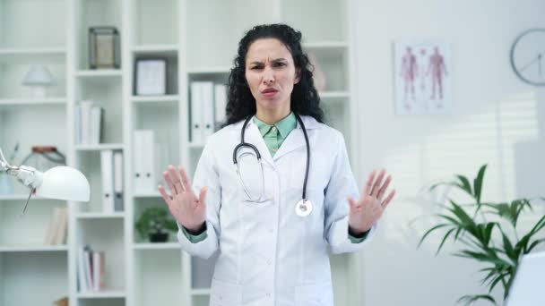 站在现代医院诊所时 身穿白色外套的女医生双手交叉 呈X字形 摇头不动 医务工作者医生表现出一种禁止 反对的姿态 — 图库视频影像