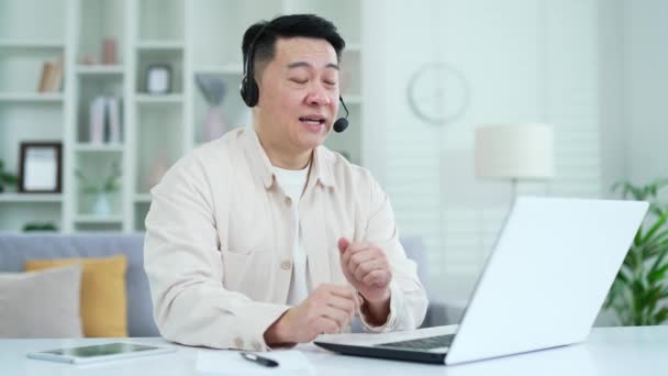 Pewny Siebie Azjatycki Biznesmen Słuchawkach Rozmawiający Przez Telefon Wideo Laptopie — Wideo stockowe