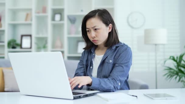 Teleurgesteld Aziatische Vrouw Las Slecht Nieuws Laptop Tijdens Het Zitten — Stockvideo