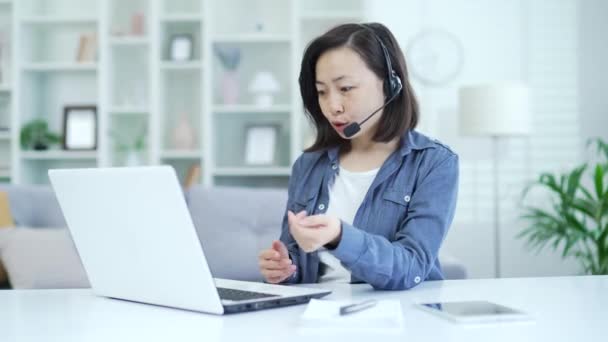 Mujer Asiática Confianza Auriculares Inalámbricos Hablando Videollamada Utilizando Ordenador Portátil — Vídeos de Stock