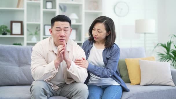 Жінка Азії Намагається Примиритися Ображеним Чоловіком Сидячи Дивані Вітальні Жінка — стокове відео