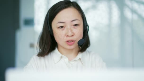 Zamknij Drzwi Azjatka Słuchawkowym Operatorze Obsługi Klienta Rozmawiająca Przez Wideo — Wideo stockowe