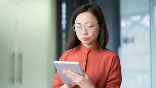 Close Smiling Asiático Empresária Usando Tablet Enquanto Escritório Moderno Funcionário — Vídeo de Stock