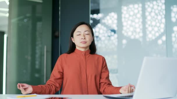 Aziatische Vrouw Mediteert Met Haar Ogen Dicht Terwijl Een Werkplek — Stockvideo