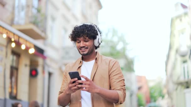 Joven Hombre Negocios Adulto Sonriendo Caminando Calle Ciudad Sosteniendo Teléfono — Vídeos de Stock