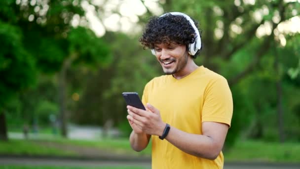 Feliz Joven Atleta Emocionado Auriculares Comprobar Los Resultados Entrenamiento Teléfono — Vídeos de Stock
