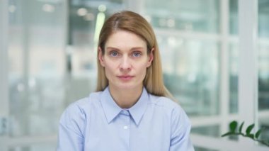 Webcam görüntüsü. Kapatın. İş kadını ofiste otururken kameraya bakarak video eğitimi alıyor. Kadın çevrimiçi çalışıyor, uzaktan bir kurs, webinar, ders ya da seminer dinliyor