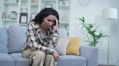 Genç üzgün esmer kadın evdeki oturma odasındaki kanepede otururken depresyona giriyor. Evde sorunlarını düşünen yalnız bir kadın. Yorgun, mutsuz, hayal kırıklığına uğramış ve kötü bir ruh hali var.