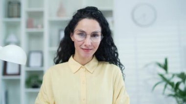 Webcam görüntüsü. Gözlüklü bir kadın evde otururken internetten e-öğrenme, video kursu dinliyor. Kadın internette çalışıyor, uzaktan bir web sitesi, seminer ya da ders dinliyor.