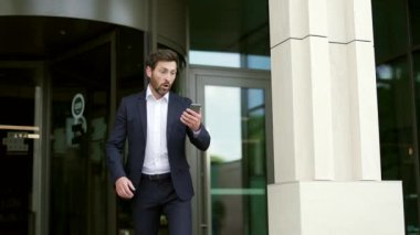 Adam aceleyle işe gidiyor. Geç saatte iş toplantısı. Endişeli iş adamı ofise gidiyor. Takım elbiseli bir erkek son teslim tarihi için acele ediyor. Zaman yönetimi. Meşgul yaşam tarzı acele ve akıllı telefona bakıyor