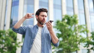 Kızgın işadamı dışarıda dururken elinde akıllı telefon tutarak duygusal konuşuyor. Shirty sinirli olgun erkek yönetici girişimci ofis binasının önünde gelişigüzel tartışıyorlar.