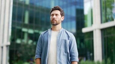 Kendine güvenen, olgun, yakışıklı, ciddi kollarını kavuşturmuş iş adamı. Kameraya bak. İş adamı girişimci çalışan bilişim geliştirme şirketi ofis yakınında bir şehir caddesi inşa ediyor.