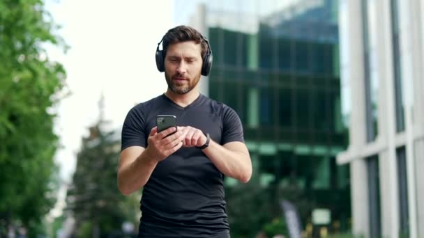 Vrolijk Actieve Man Sportief Wandelen Met Koptelefoon Mobiele Telefoon Genieten — Stockvideo