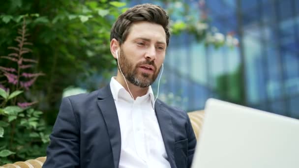 Hombre Negocios Comunica Remotamente Una Videollamada Mientras Está Sentado Banco — Vídeo de stock