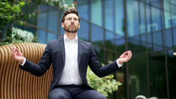 Расслабляющий Спокойный Бизнесмен Медитирующий Скамейке Возле Офисного Здания Городского Парка — стоковое видео
