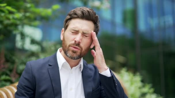 不幸な成熟したオフィスワーカーのビジネスマンは 緊張頭痛の痛みを感じる現代のビジネスセンターで慢性片頭痛の高いまたは低い圧力に悩まされ 起業家男性の企業疲労を抑えました — ストック動画