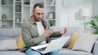 Öfkeli adam internetteki video görüşmesinde tartışıyor uzaktan iletişim kuruyor. Tatminsiz kötü erkek girişimci serbest yazar tartışmaları evde günlük giysiler içinde oturup 