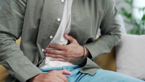 クローズアップされた男の手は 突然強い腹痛 胃炎の問題を感じるソファに座っています 自宅で下痢を中毒している男性 ペプチッド潰瘍膵炎 — ストック動画