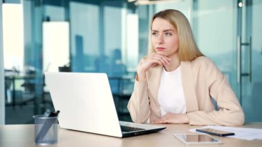 Genç iş kadını, modern ofiste otururken dizüstü bilgisayar üzerinde çalışırken yeni fikirlerin ilham verici bir anında hareket gösteriyor. Çalışan sorunu çözmek için cevabı buldu.
