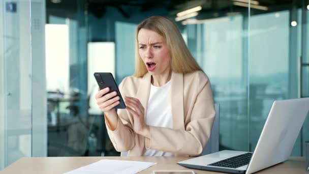 Chockad Ung Affärskvinna Läsa Dåliga Nyheter Smartphone När Sitter Arbetsplatsen — Stockvideo