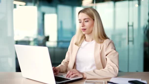 Mutlu Genç Kadını Modern Ofisteki Yerinde Otururken Dizüstü Bilgisayardaki Işini — Stok video