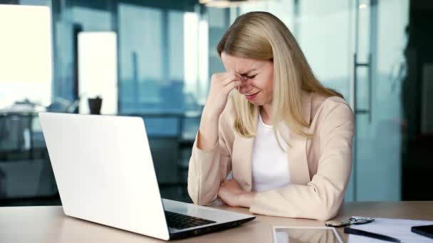 悲しい若い女性従業員は 現代のオフィスで職場に座っている精神的苦痛に苦しんで泣いています 失望した女性は職場で問題を抱え 心配し うつ病を感じます — ストック動画