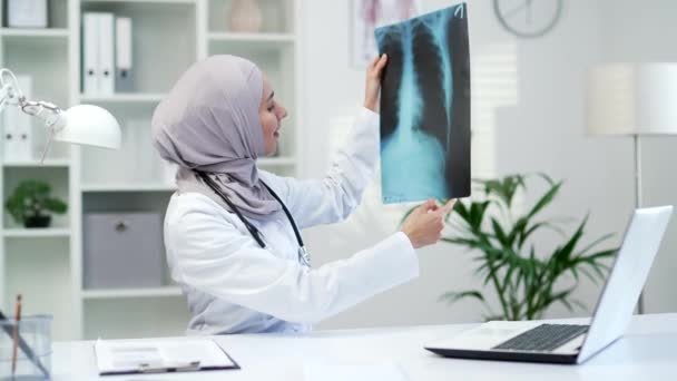 Sebevědomý Muslimský Lékař Vyšetřující Rentgenový Snímek Při Sezení Pracovišti Nemocniční — Stock video