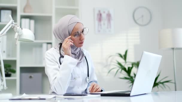 Överarbetad Muslimsk Kvinnlig Läkare Lider Trötthet Och Huvudvärk Medan Arbetar — Stockvideo