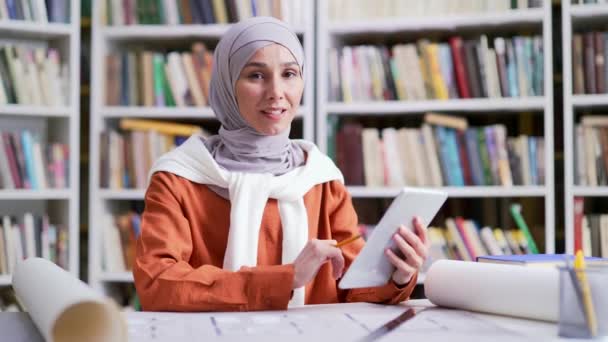 Mosolygó Muszlim Diáklány Portréja Hidzsábon Táblagéppel Kampusz Könyvtárában Stílusos Barátságos — Stock videók
