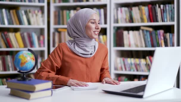 Maestra Musulmana Hiyab Dando Lecciones Videollamada Usando Laptop Espacio Biblioteca — Vídeo de stock