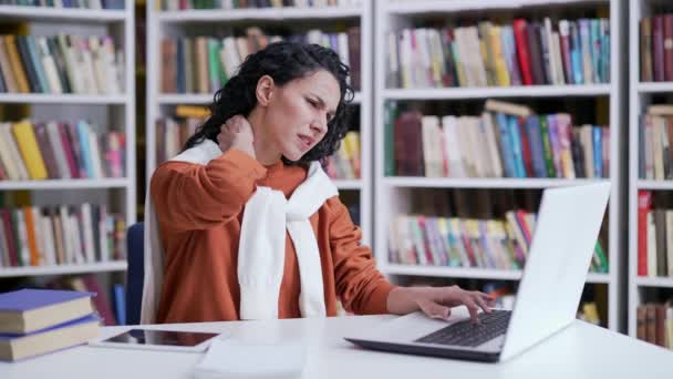 캠퍼스 도서관 공간에 앉아있는 노트북에서 일하는 통증으로 고통받는 피곤한 Massages — 비디오