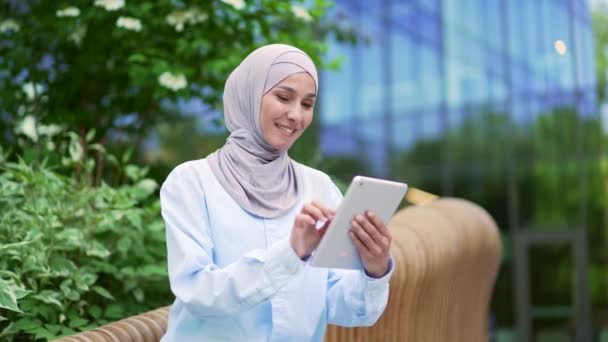 Mladá Usměvavá Muslimka Hidžábu Používá Tablet Který Sedí Lavičce Ulici — Stock video
