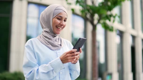 Близько Молода Усміхнена Мусульманська Жінка Працівник Хіджабі Використовує Смартфон Стоїть — стокове відео