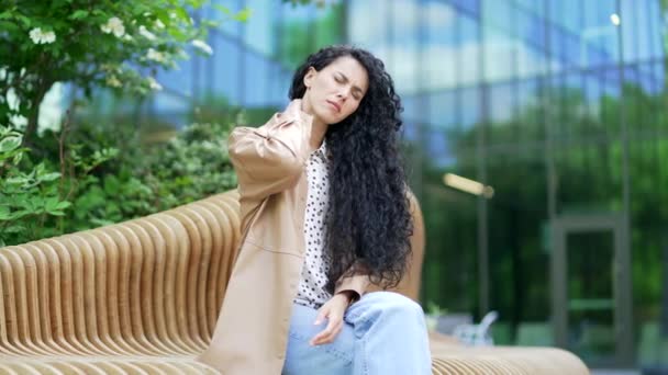 사무실 거리에 벤치에 앉아있는 통증으로 마사지 문질러 근육으로 그녀의 스트레칭 — 비디오