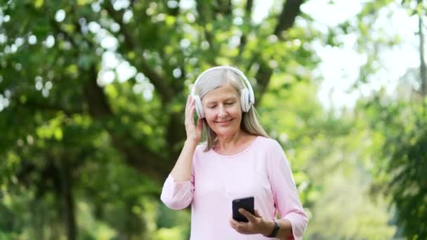 Senior Aktivní Šedovlasá Žena Procházející Sluchátky Mobilní Telefon Těší Poslech — Stock video