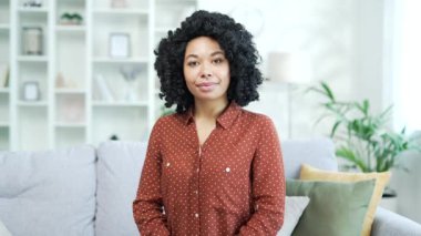 Webcam genç Afro-Amerikan kadın internet üzerinden e-öğrenme, video kursu dinleyip evdeyken kameraya bakıyor. Siyahi kadın internette ders çalışıyor, uzaktan bir webinar, seminer ya da ders dinliyor.