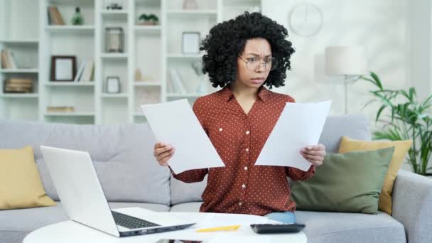 年轻的非洲裔美国女会计师坐在家里的办公室里 对纸张工作感到困惑 黑人妇女金融家看了这些文件 无法理解问题的症结所在 — 图库视频影像