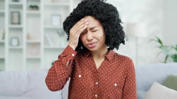 Zamknij Drzwi Młoda Afroamerykanka Cierpiąca Ból Głowy Siedząc Kanapie Salonie — Wideo stockowe