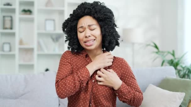 过敏发作非洲裔美国年轻女性在家中沙发上出现过敏反应或蚊虫叮咬的抓痒 黑人妇女因压力划伤身体 — 图库视频影像