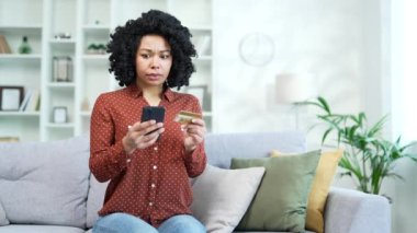 Hüsrana uğramış genç Afrikalı Amerikalı kadın evde oturan akıllı telefondan kredi kartı numarasını girerken dolandırıcılığı keşfetti. Üzgün siyah kadın hesabından çalınan parayı gördü.