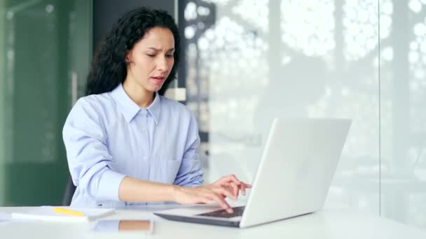 混乱した女性従業員は オフィスに座っている間 ラップトップ上のコンピュータプログラムのパフォーマンスが低いと不満を言います 若い女性は デバイスの仕事に不満を持っています インターネットやサービス — ストック動画