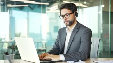 Müşteri desteğinde çalışan bir şirket operatörü bir dizüstü bilgisayar kullanarak bir video görüşmesinde konuşur. Kablosuz kulaklık takmış bir merkez ajanı ofisteki müşterilere şikayette yardımcı oluyor. Çevrimiçi danışma