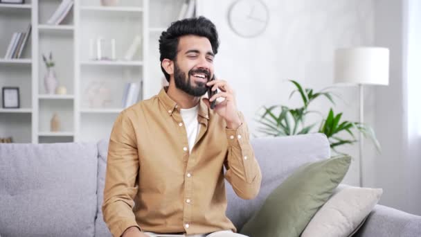 Šťastný Mladý Pohledný Muž Mluví Smartphone Zatímco Sedí Pohovce Obývacím — Stock video