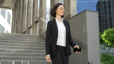 Resmi takım elbiseli gülümseyen genç işadamı, ofis binasının yakınındaki caddede yürüyen bir akıllı telefon kullanıyor. Ekrana bakıp cep telefonundan gelen mesajı okuyan mutlu esmer kız öğrenci.