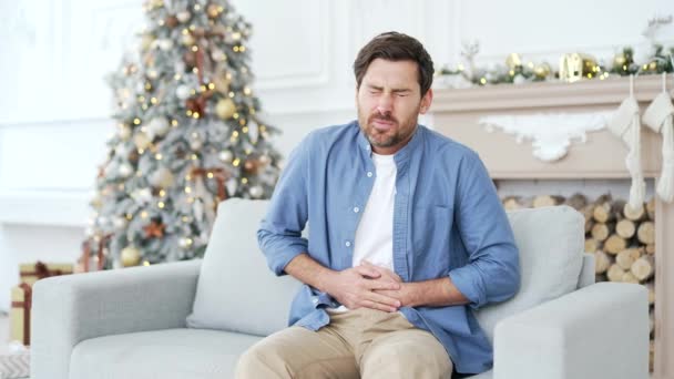 Zdenerwowany Człowiek Odczuwa Ból Brzucha Siedząc Kanapie Salonie Domu Zimą — Wideo stockowe