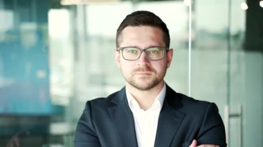 İş yerindeki resmi takım elbiseli ve gözlüklü ciddi başarılı iş adamının portresi. İçerideki kameraya bakarak poz veren kendine güvenen girişimci. Müdürün kafasından.