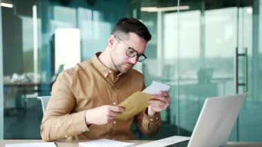 Hayal kırıklığına uğramış genç sakallı iş adamı, iş yerindeki bir masada oturan kötü haberlerle birlikte mektup okuyor. Hüzünlü girişimci, nahoş bir haber alınca hayal kırıklığına uğradı.